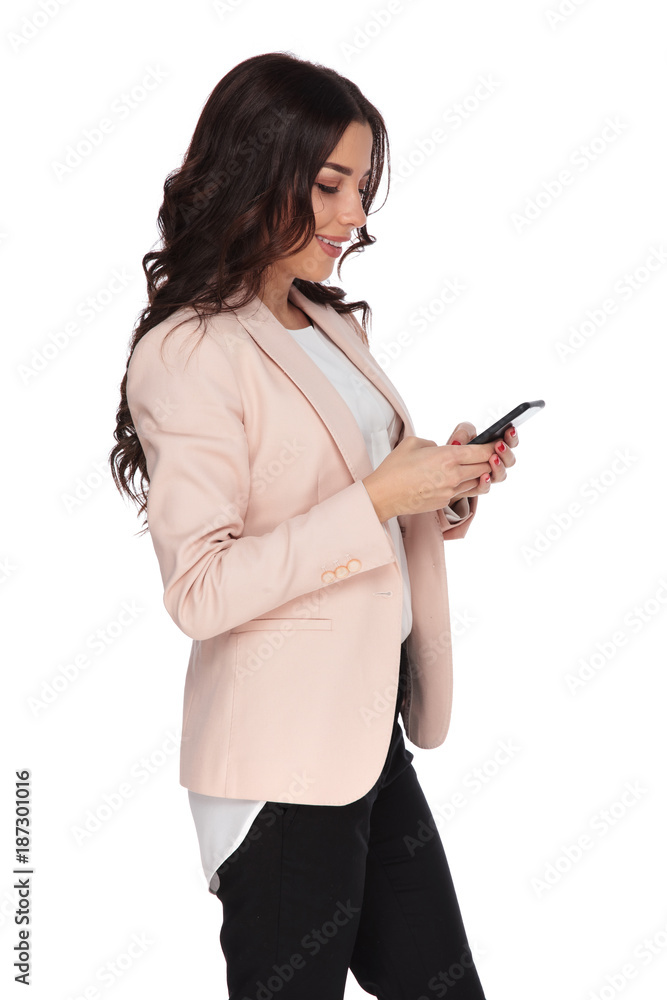 side view of a young business woman texting on her side view of a young business woman texting on her