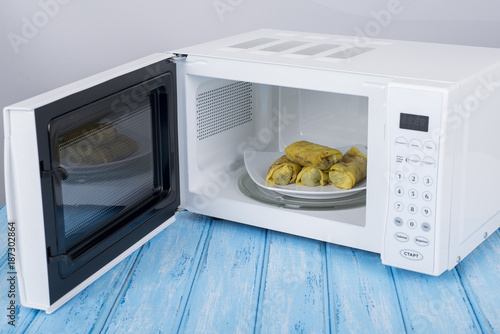 white microwave oven, on a blue wooden surface for heating food
