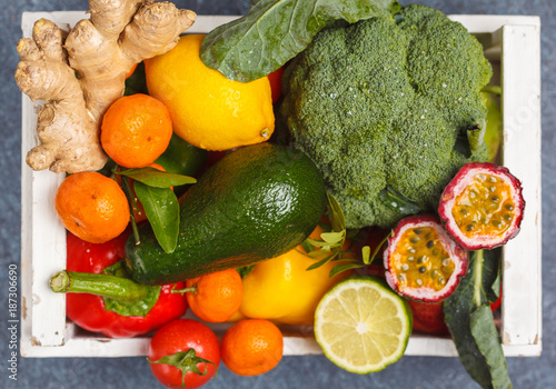 Fresh fruits and vegetables in a white wooden box. A healthy vegetarian farm food concept. Top view