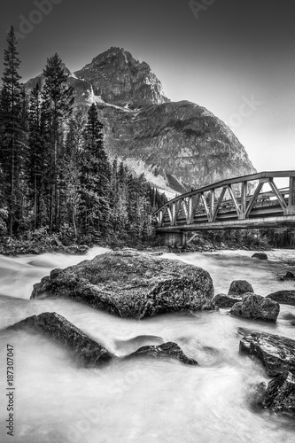Flowing water under a scenic bridge with a beautiful view of the Canadian Rocky-Mountains