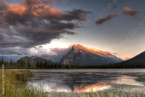 Pink clouds moving over the top of a mountain during a spectacular sunset in Banff-Nationalpark, Canada