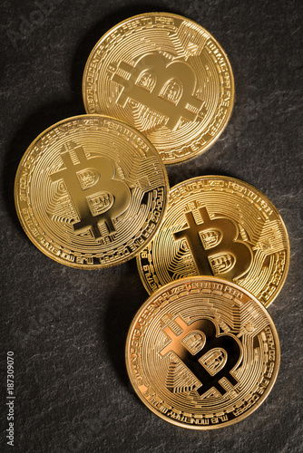 vier Bitcoin Münzen auf Schieferuntergrund