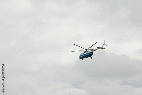 Commercial passenger helicopter mi-8 with a working propeller flying against sky
