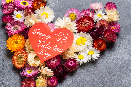 Heart made from flowers on grey background