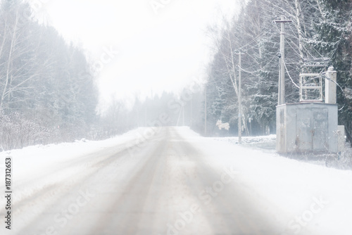 winter road covered by snow and electrical junction box