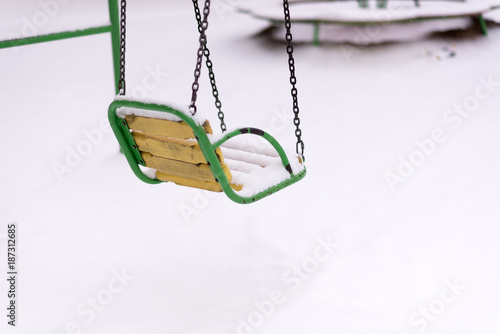 Swing covered with snow as outdoor facility