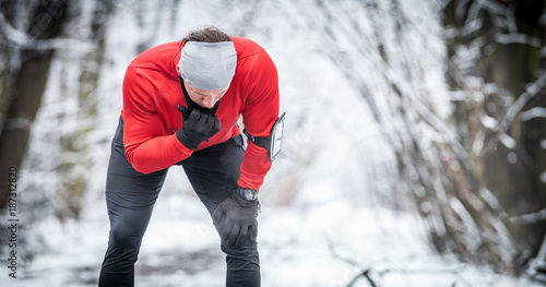 Winter running exercise, runner wearing warm clothes has break