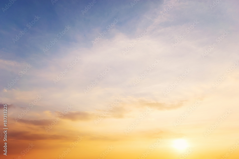 Fototapeta premium Błękitne i pomarańczowe światło słońca przez chmury na niebie