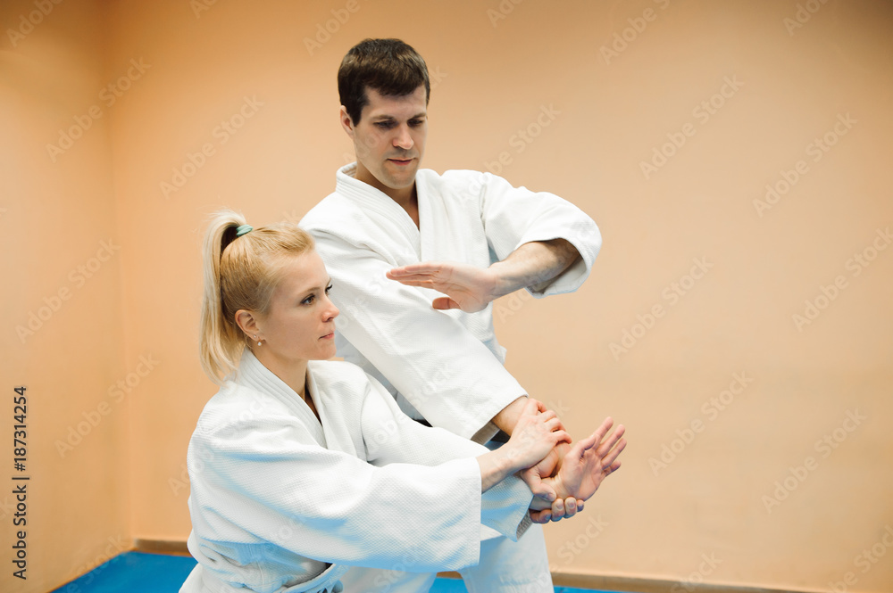 Obraz premium Man and woman fighting at Aikido training in martial arts school