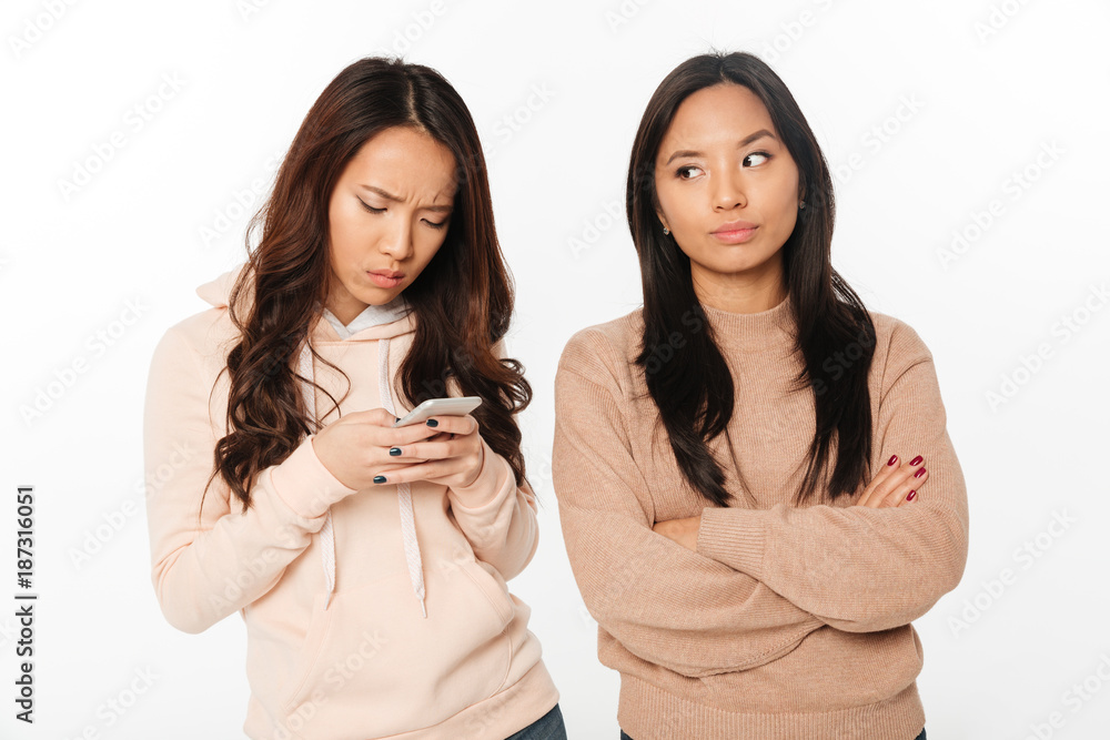 Asian girl displeased because of her sister Asian girl displeased because of her sister