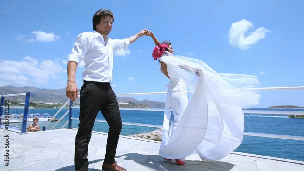 wedding dance. wedding day. newlyweds are dancing on the waterfront. bride and groom dance near the picturesque blue sea. Greece wedding dance. wedding day. newlyweds are dancing on the waterfront. bride and groom dance near the picturesque blue sea. Greece
