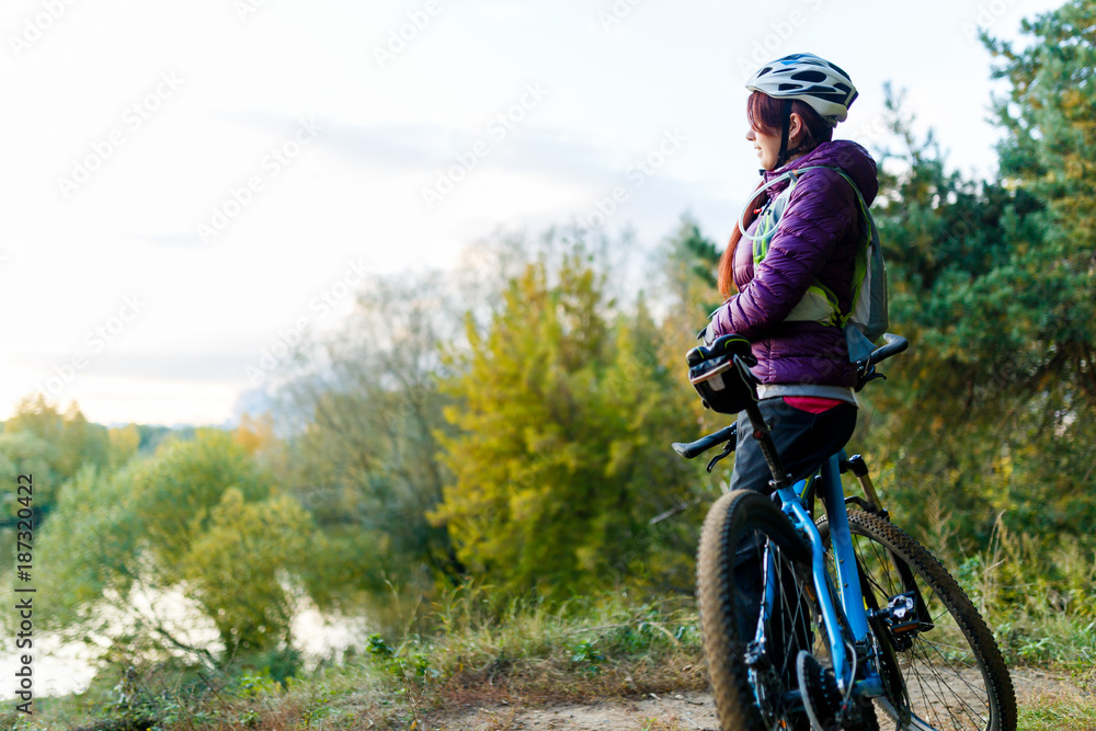 Fototapeta premium Image of girl with bicycle in helmet in autumn