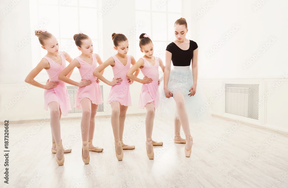 Naklejka premium Teacher helping her students during dance class