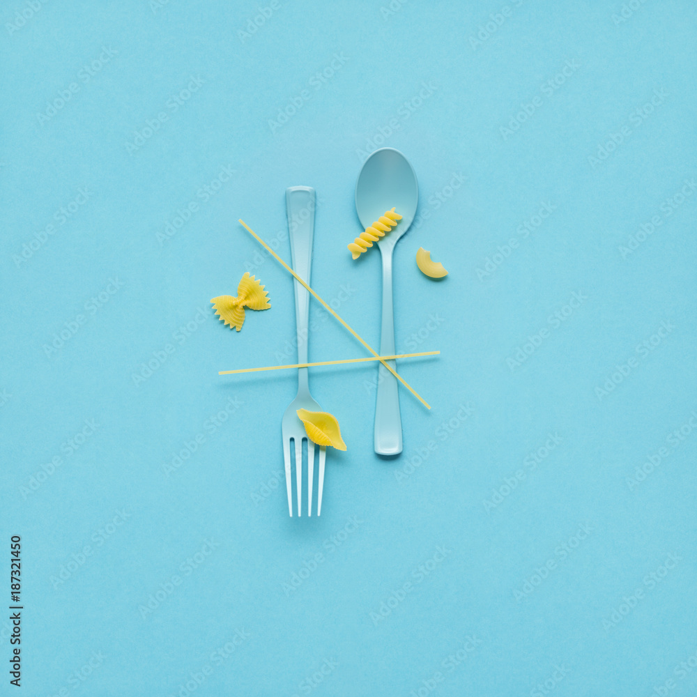 Tasty pasta / Creative still life photo of fork and spoon with raw pasta on blue background. Tasty pasta / Creative still life photo of fork and spoon with raw pasta on blue background.