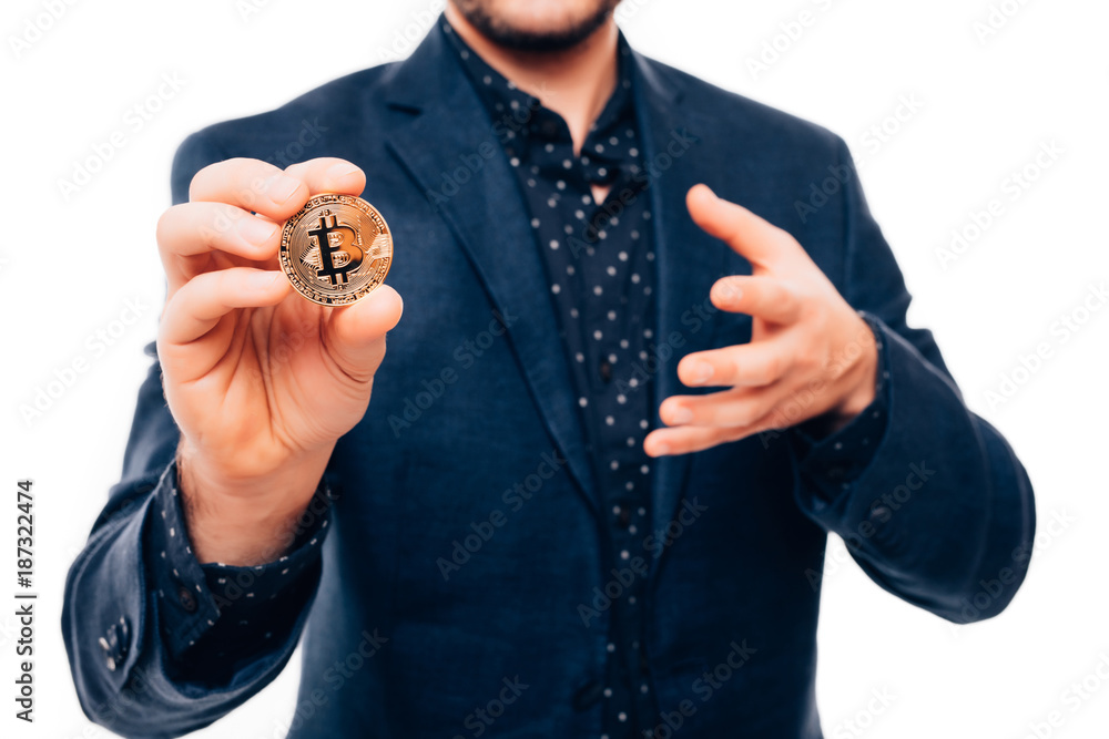 Fototapeta premium Close up of hands of handsome man pointed gold bitcoin on camera isolated on white background