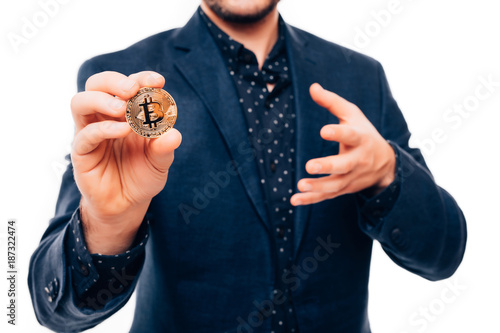 Close up of hands of handsome man pointed gold bitcoin on camera isolated on white background