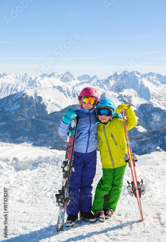 Smiling children enjoying winter vacations in mountains . Ski Sun  Snow and Fun.