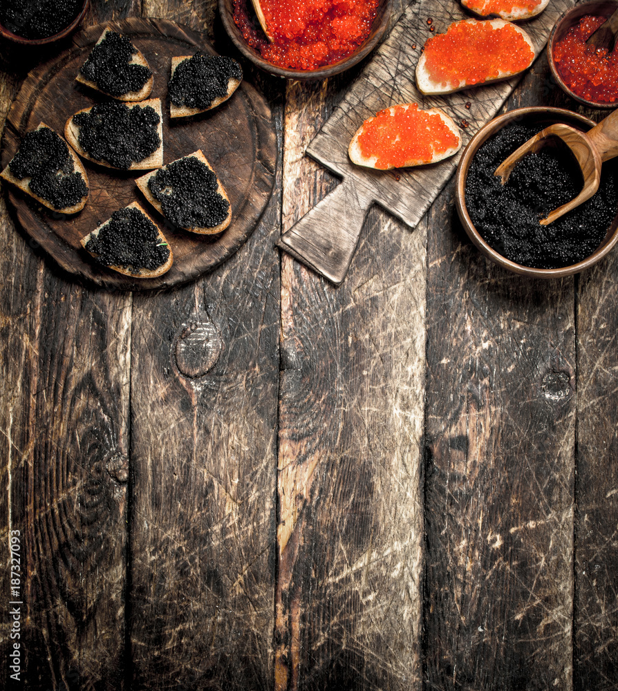 Black and red caviar in old wooden bowls. Black and red caviar in old wooden bowls.