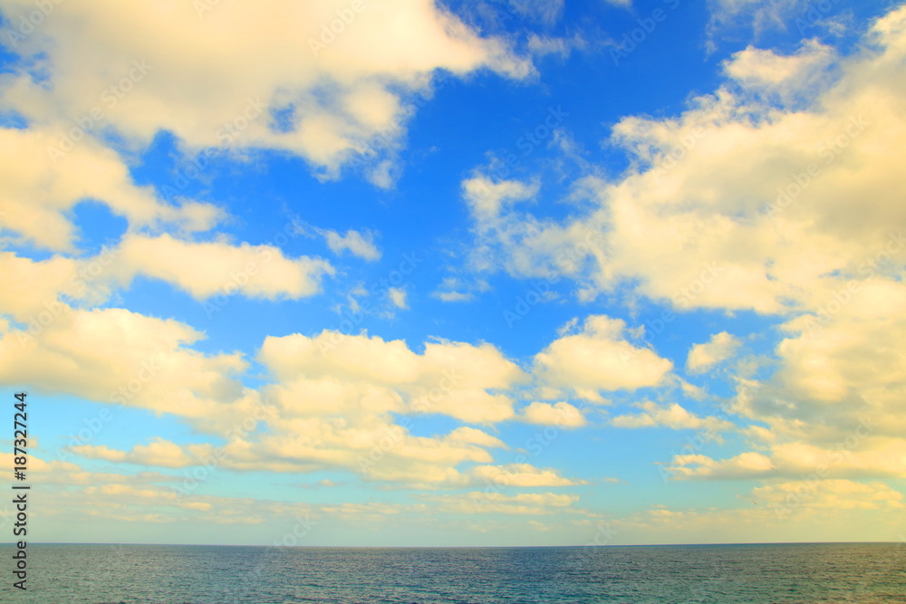Sea horizon and cloudy blue sky
