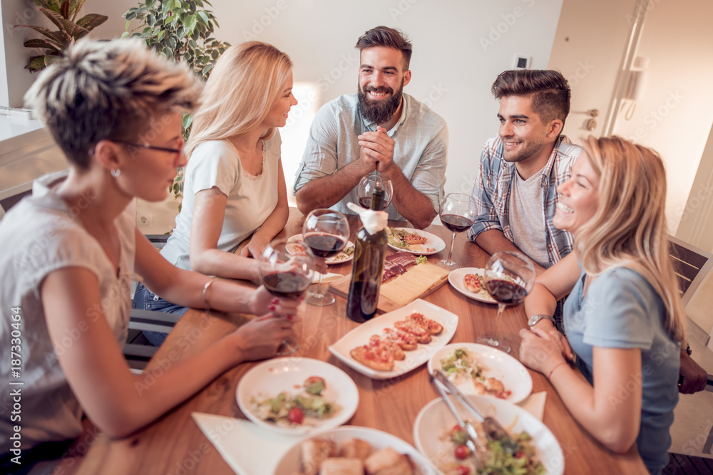 Group of friends enjoying meal at home together. Group of friends enjoying meal at home together.