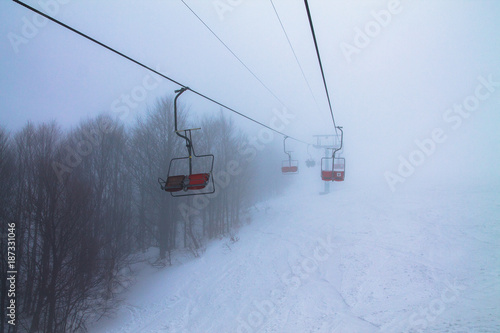 chairlift in misty mountains
