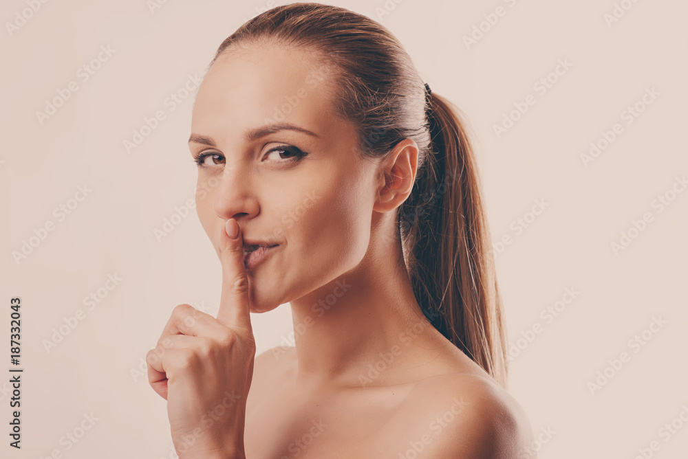 portrait of a young beautiful woman calling for silence on a white background portrait of a young beautiful woman calling for silence on a white background