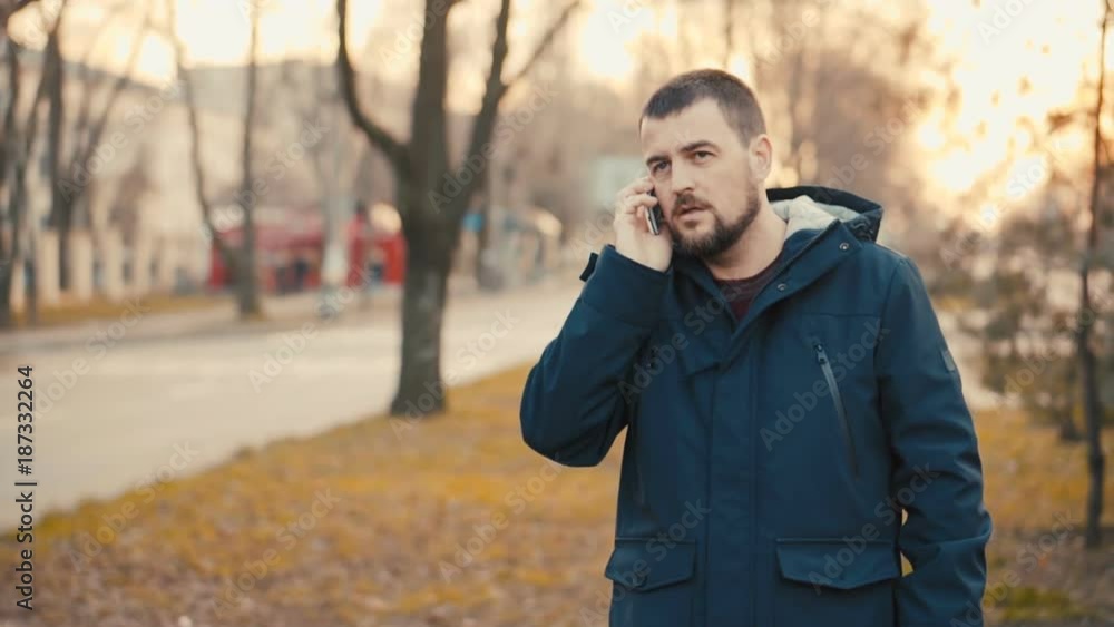 Young man is talking on the phone in the park. Young man is talking on the phone in the park.