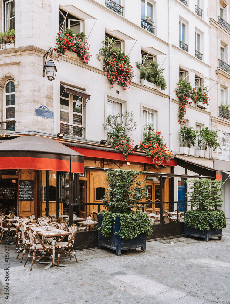 Naklejka premium Typowy widok na paryskiej ulicy ze stołami Brasserie (kawiarnia) w Paryżu, Francja