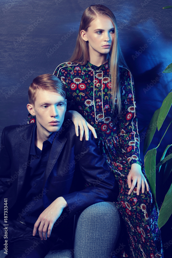 Young fashion couple sitting on a sofa.