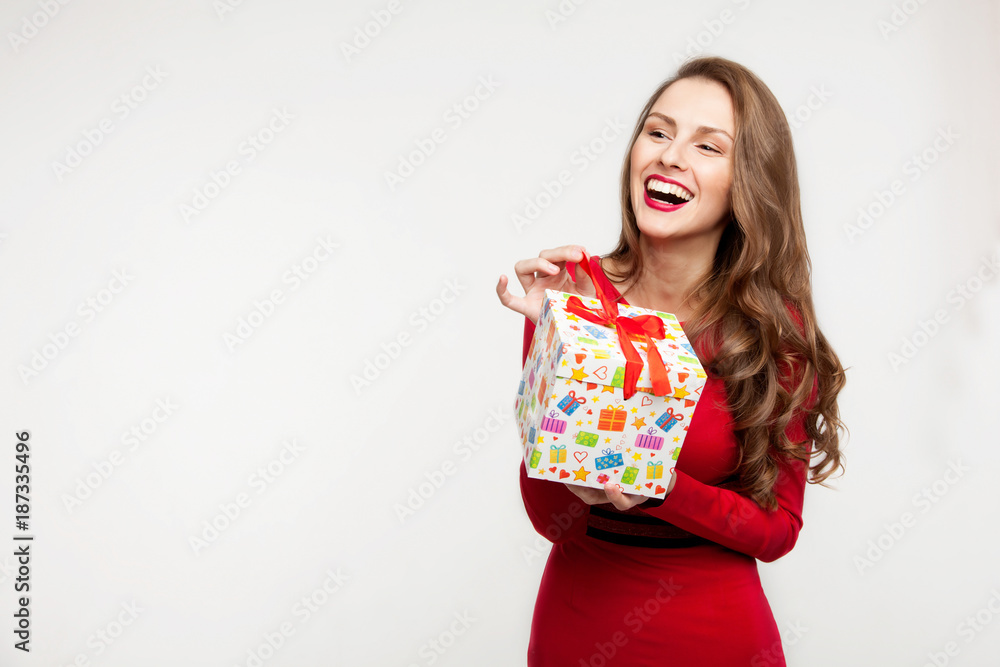 Fototapeta premium the brunette girl is holding a present and laughing. For Valentine's Day. On white background