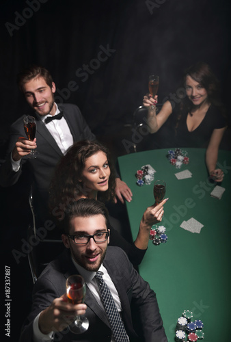 Group of young rich people is playing poker in the casino