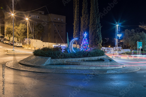 Decorated Christmas tree, Chanukah Menorah and the Muslim Crescentset on the UNESCO square for tolerance and peace in front of Bahai garden in Haifa in Israel photo