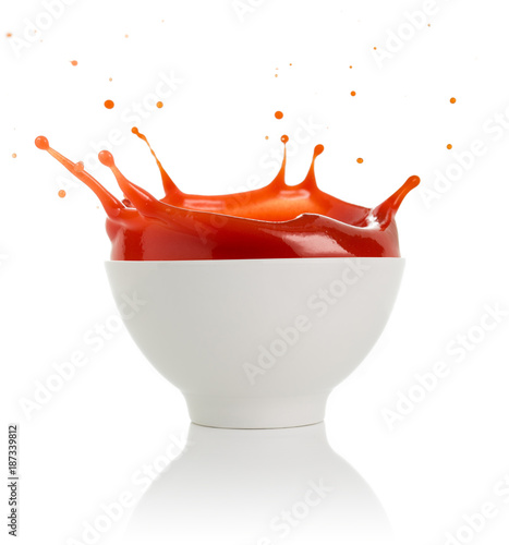 tomato soup splashing out of a bowl isolated on white