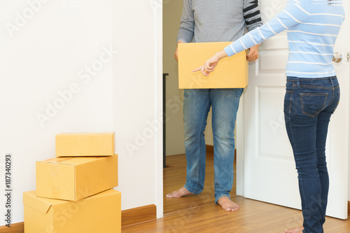 Couple holding boxes into their home - moving house concept. © petzshadow