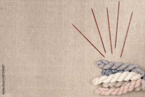 Pastel colors hank of yarn and wooden knitting needles