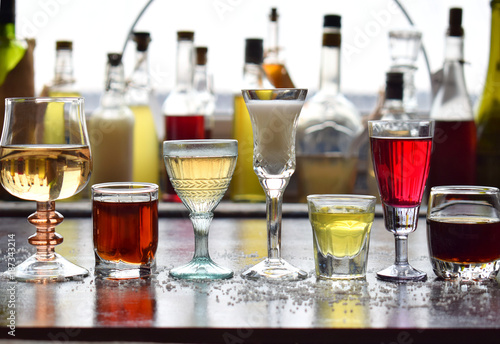 Selection of alcoholic drinks. Set of wine, brandy, liqueur, tincture, cognac, whiskey in glasses, bottles. Large variety of alcohol and spirits for making cocktails and drink. Copy space for text