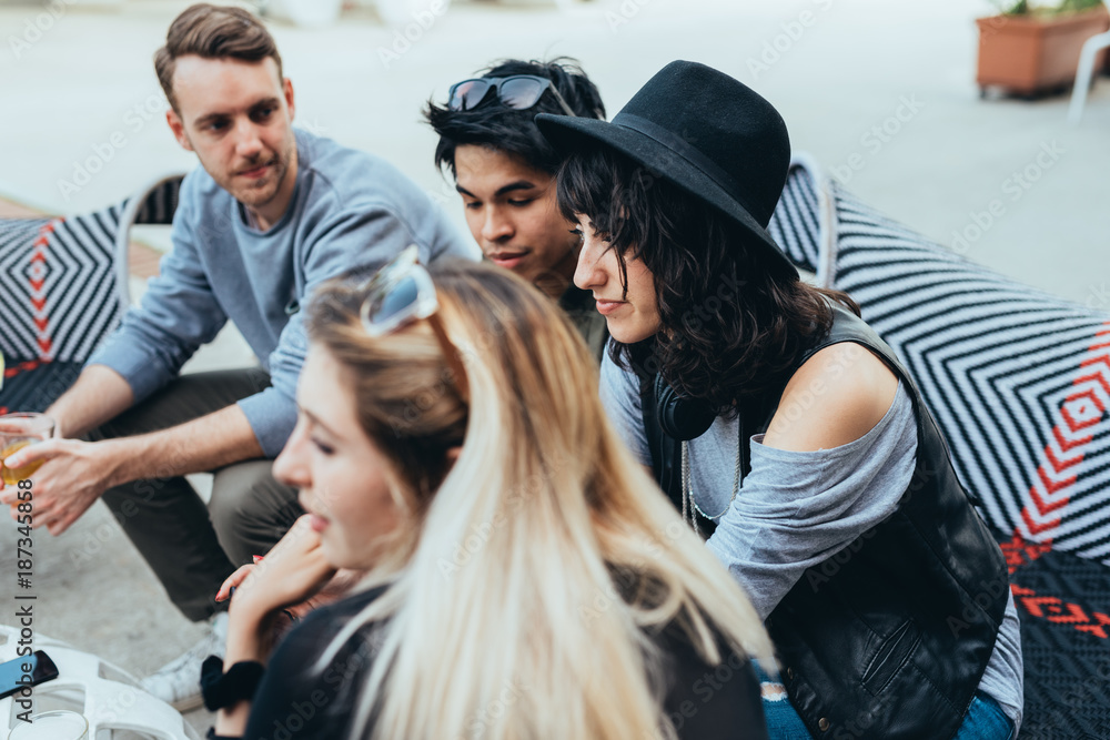 Group of friends millennials sitting outdoor bar using smart phone - technology, internet, happy hour concept Group of friends millennials sitting outdoor bar using smart phone - technology, internet, happy hour concept