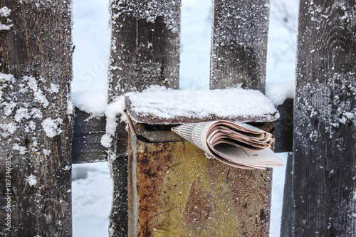 Post box with newspaper in the winter on the street