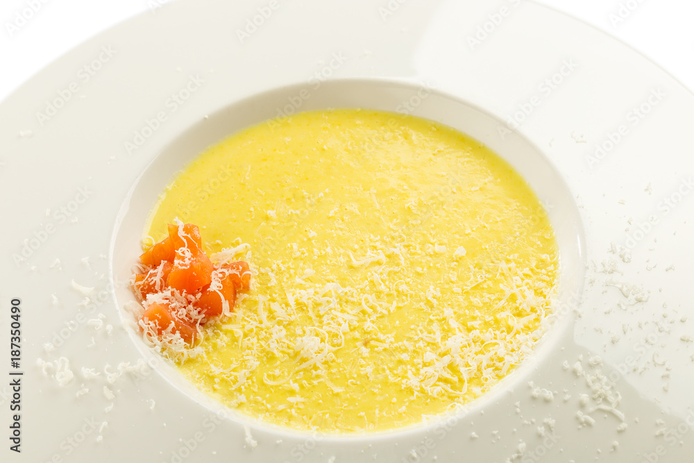 Cheese cream soup with salmon and grated parmesan on white plate isolated on white Cheese cream soup with salmon and grated parmesan on white plate isolated on white