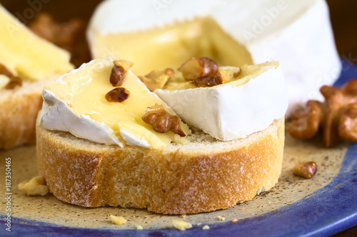 Baguette with camembert cheese and walnuts  photographed with natural light  Selective Focus  Focus on the first walnut piece on the bread 