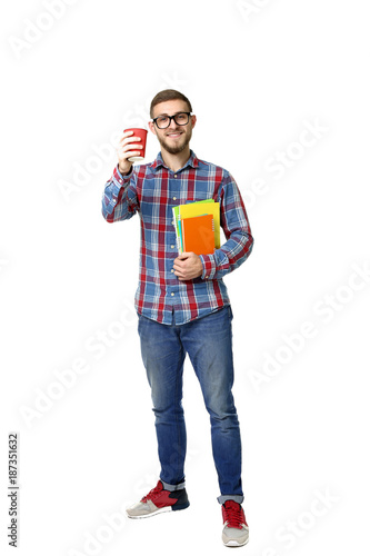 Young man with notebooks and cup of coffee on white background