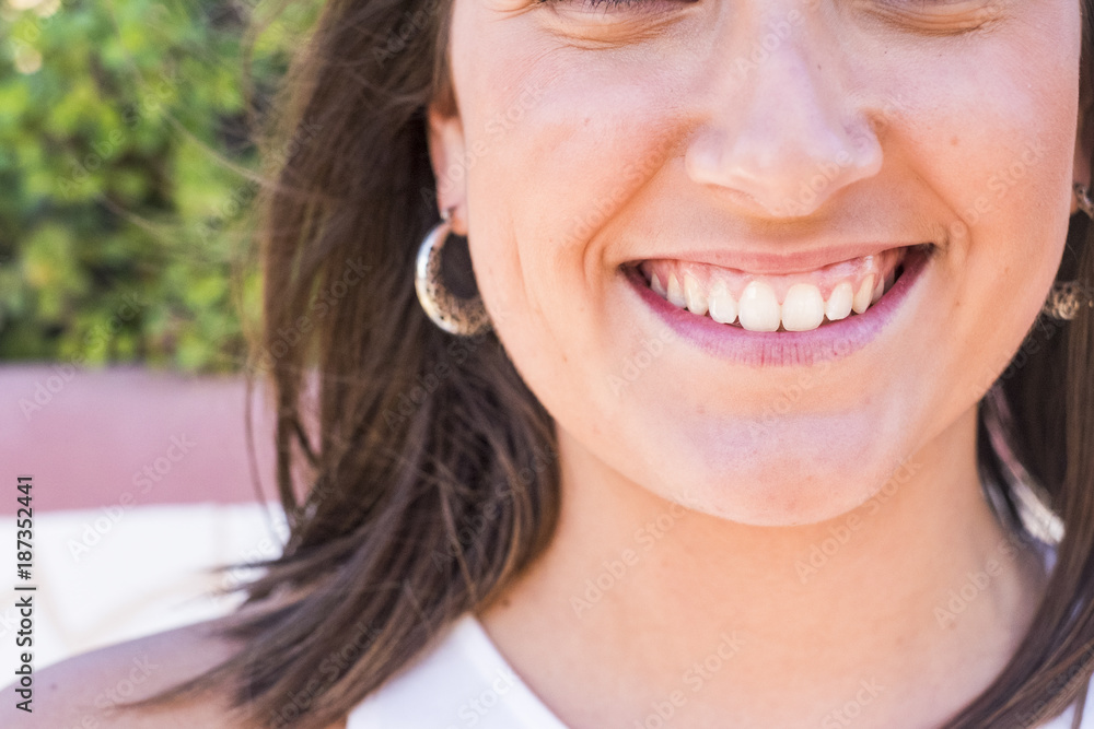 close up of a young woman smiling with perfect teeth close up of a young woman smiling with perfect teeth