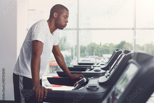 Young man in gym run on treadmill