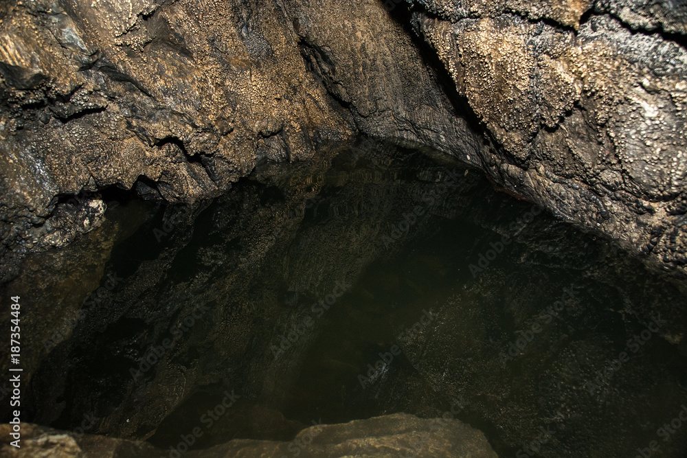 View inside a deep cave. Underground lake.