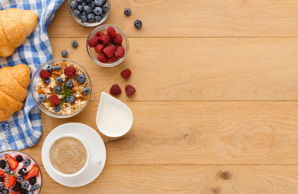 Continental breakfast with croissants and berries on natural wood Continental breakfast with croissants and berries on natural wood