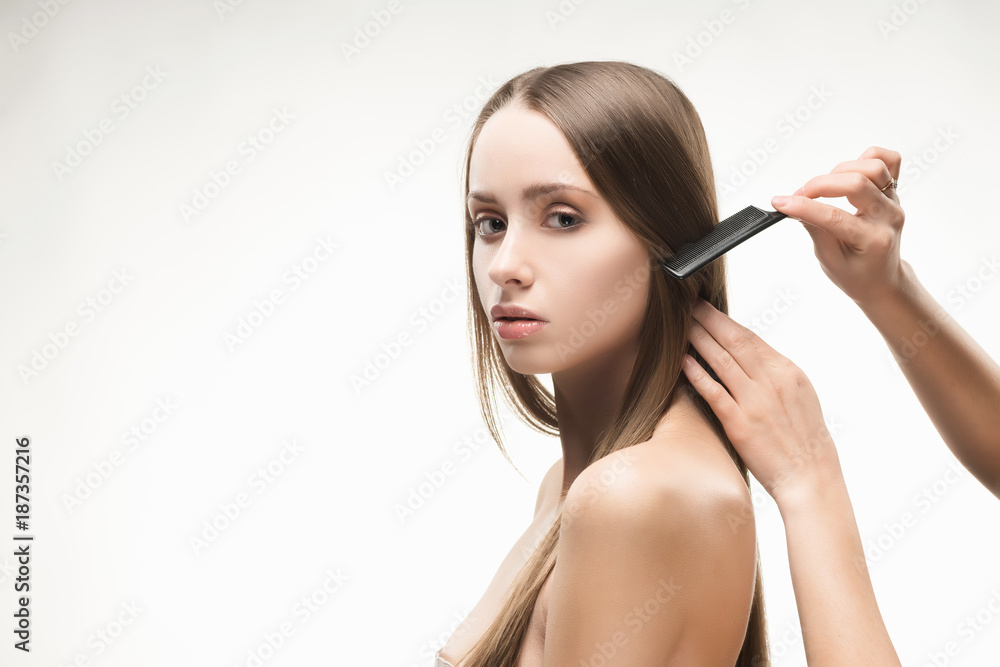 Obraz premium Beautiful young long-haired girl brushed by the stylist.
