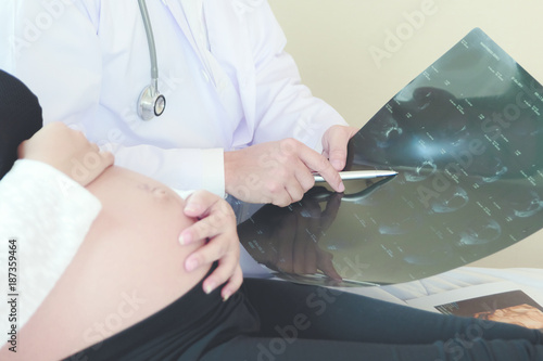 Wallpaper Mural Pregnant woman is lying in bed while doctor showing the ultrasound image. Torontodigital.ca