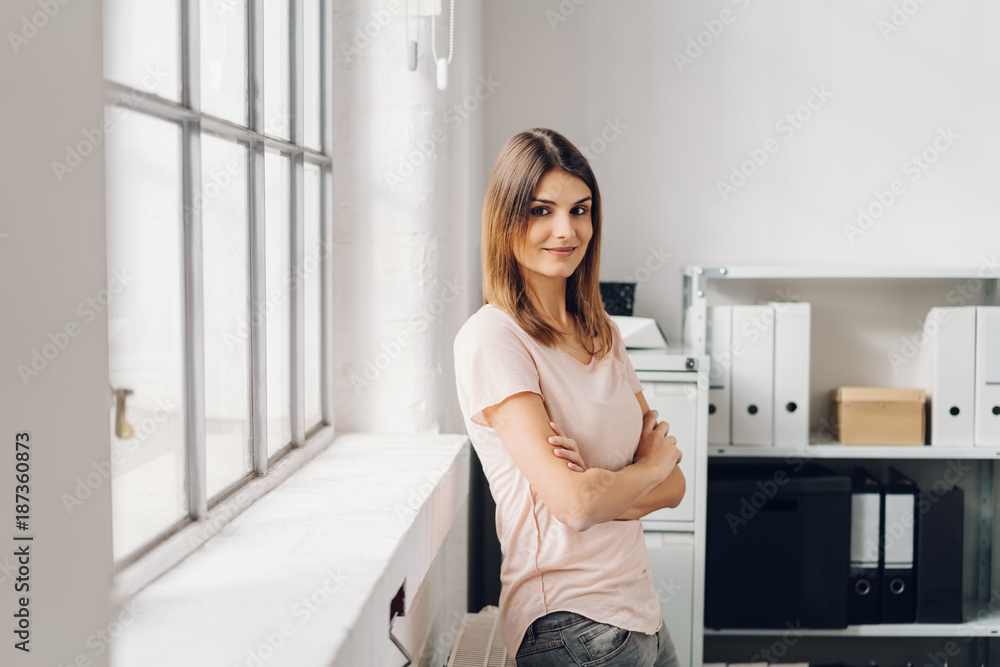 Young cheerful woman standing in office Young cheerful woman standing in office