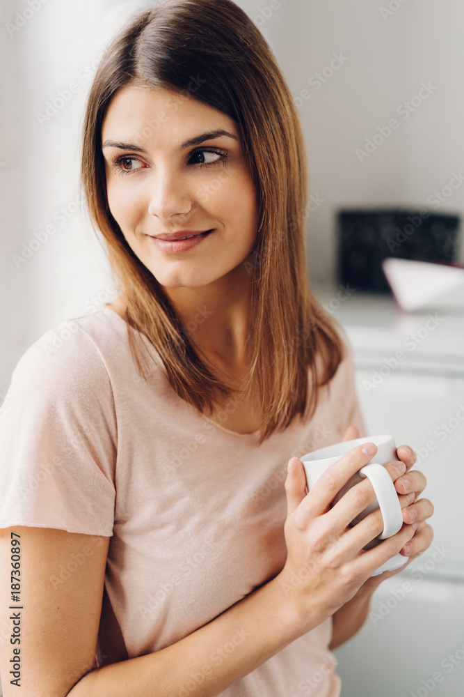 Woman looking over her shoulder as she holds mug