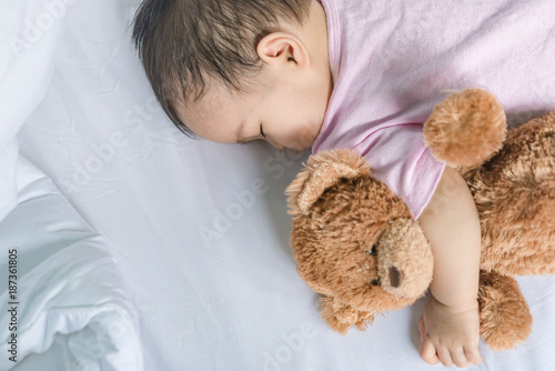 Asian baby sleeping on the bed,thailand people,relax time,bear doll